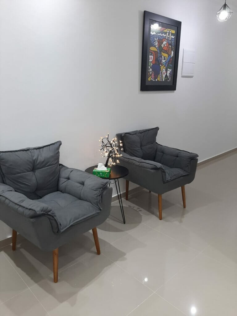 Sala de espera com poltronas e quadro decorativo