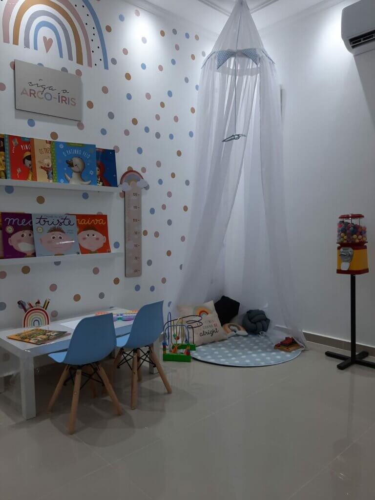 Espaço lúdico infantil com dossel, livros e mesinha